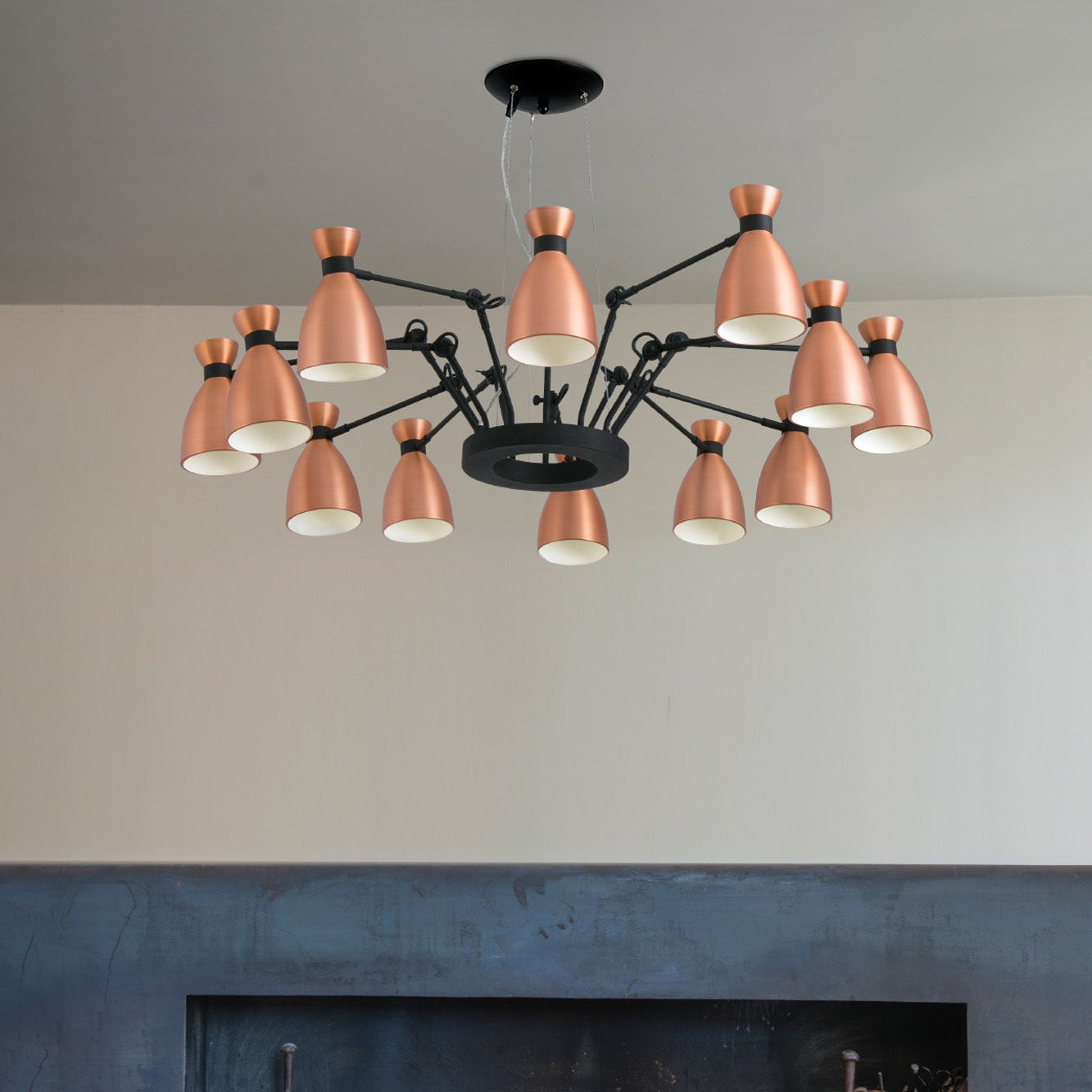 Modern chandelier with copper-colored lights in a living room setting.