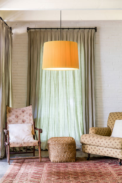 Living room with two armchairs, a ottoman, and a large lamp with an orange shade.
