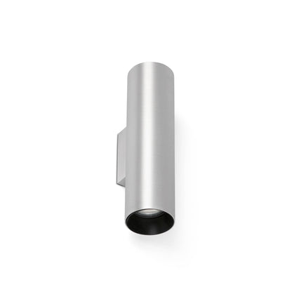 A modern cylindrical wall sconce in a brushed silver finish with a black interior, shown against a plain white background.