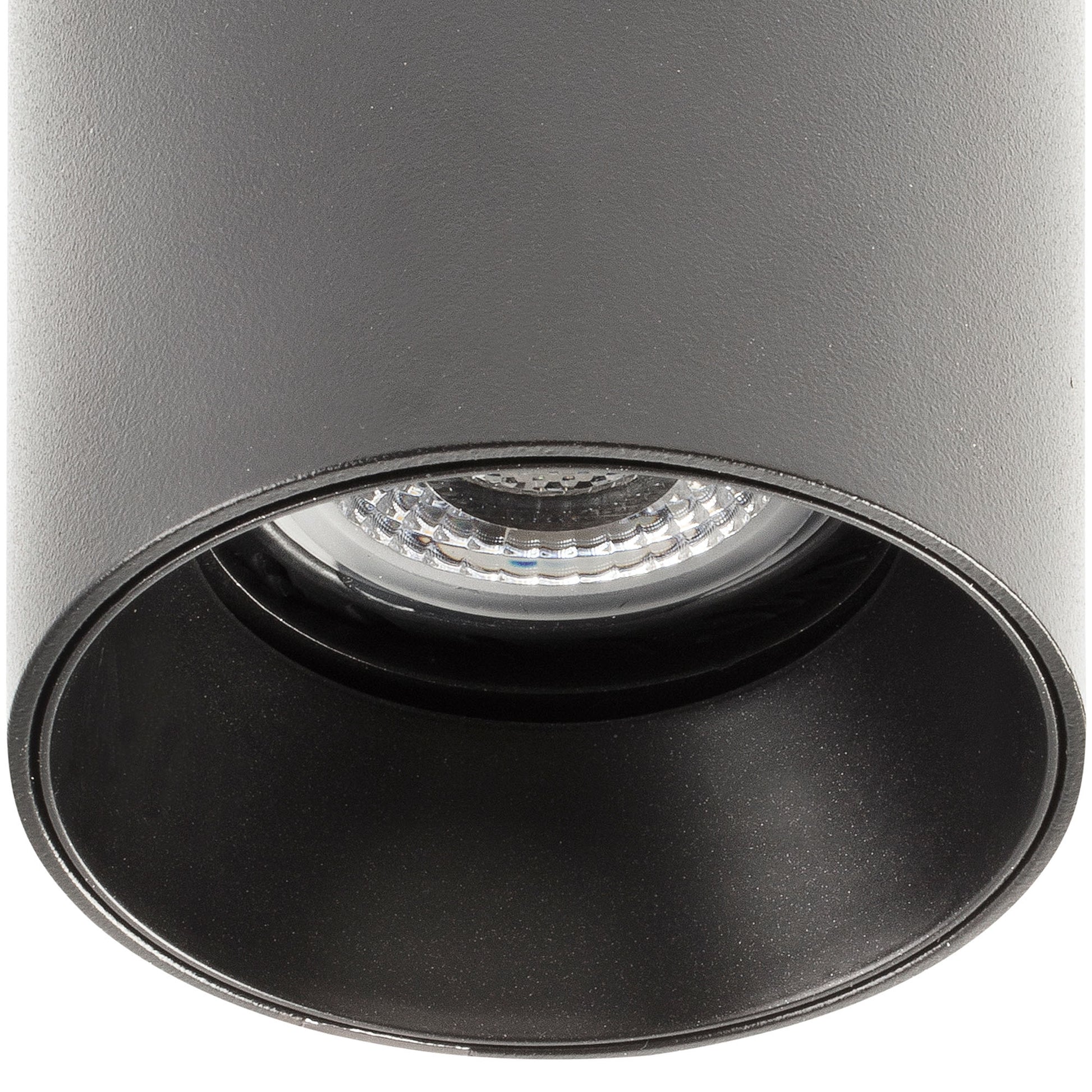 Black cylindrical spotlight with a clear lens on a white background