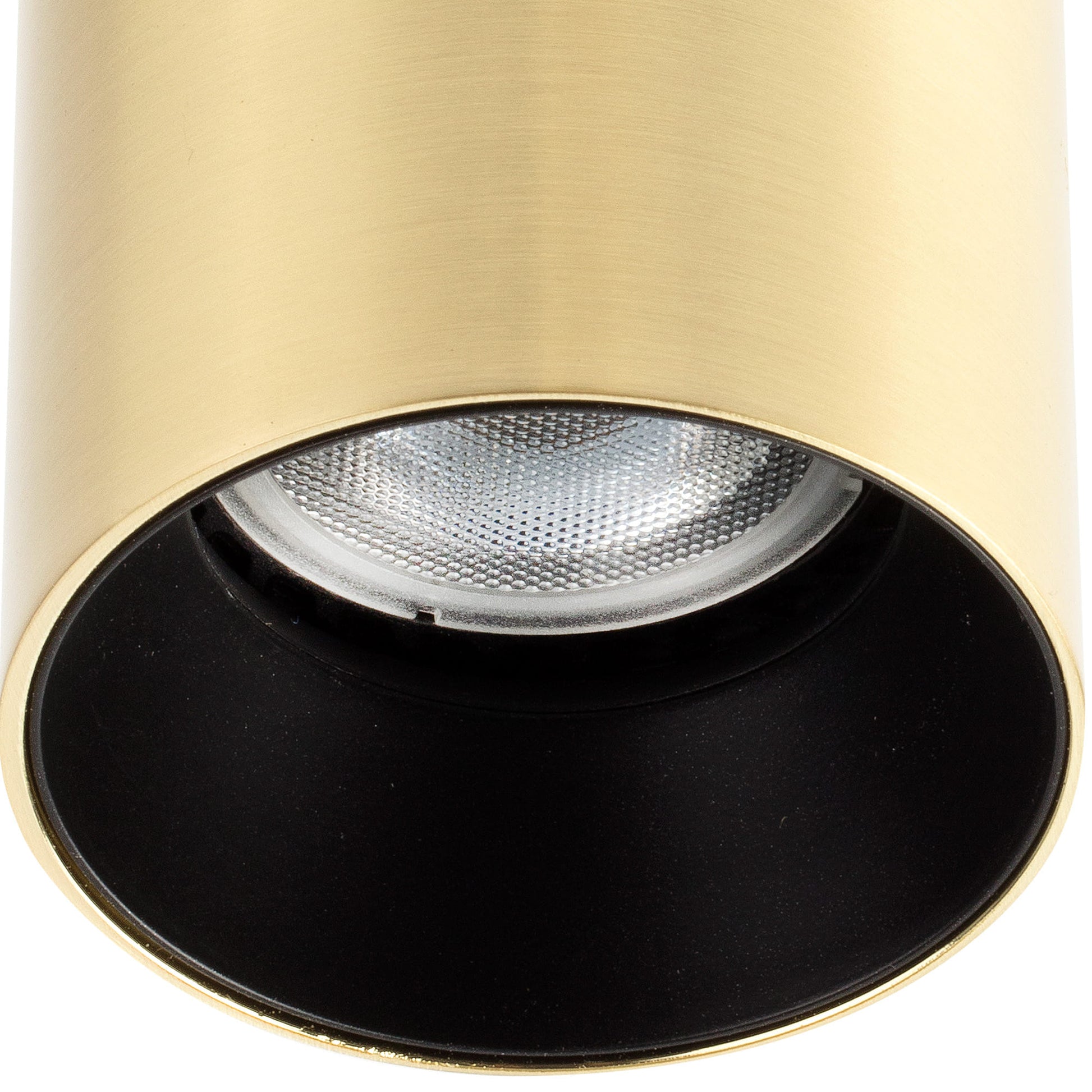 Close-up of a gold and black spotlight with a white bulb inside.