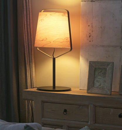 Napoleon III style sideboard with lamp and framed pictures in a cozy room.