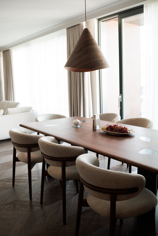 The Sakura dark walnut conical wooden pendant light suspended above a rectangular dining table in a contemporary dining room. Available to buy at the VXR Space store.