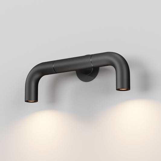 Modern black wall-mounted light fixture on a gray background