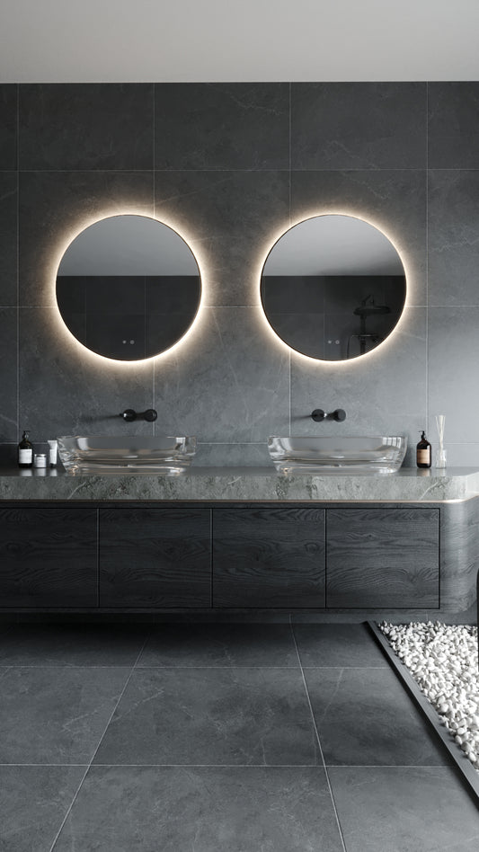 The W0387 round illuminated LED bathroom mirrors installed above a double vanity in a contemporary dark tile bathroom. Available to buy at the VXR Space store.