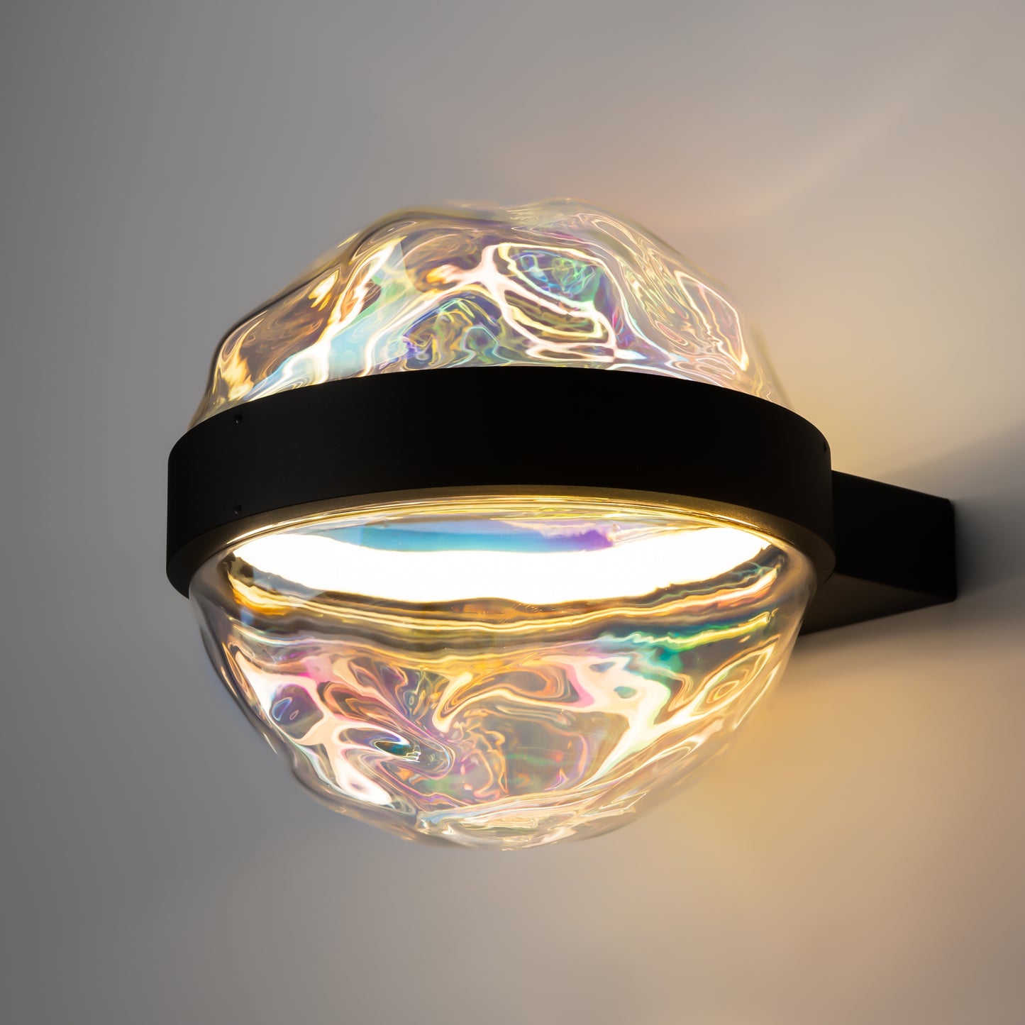 Decorative wall light with iridescent glass shade on a gray background