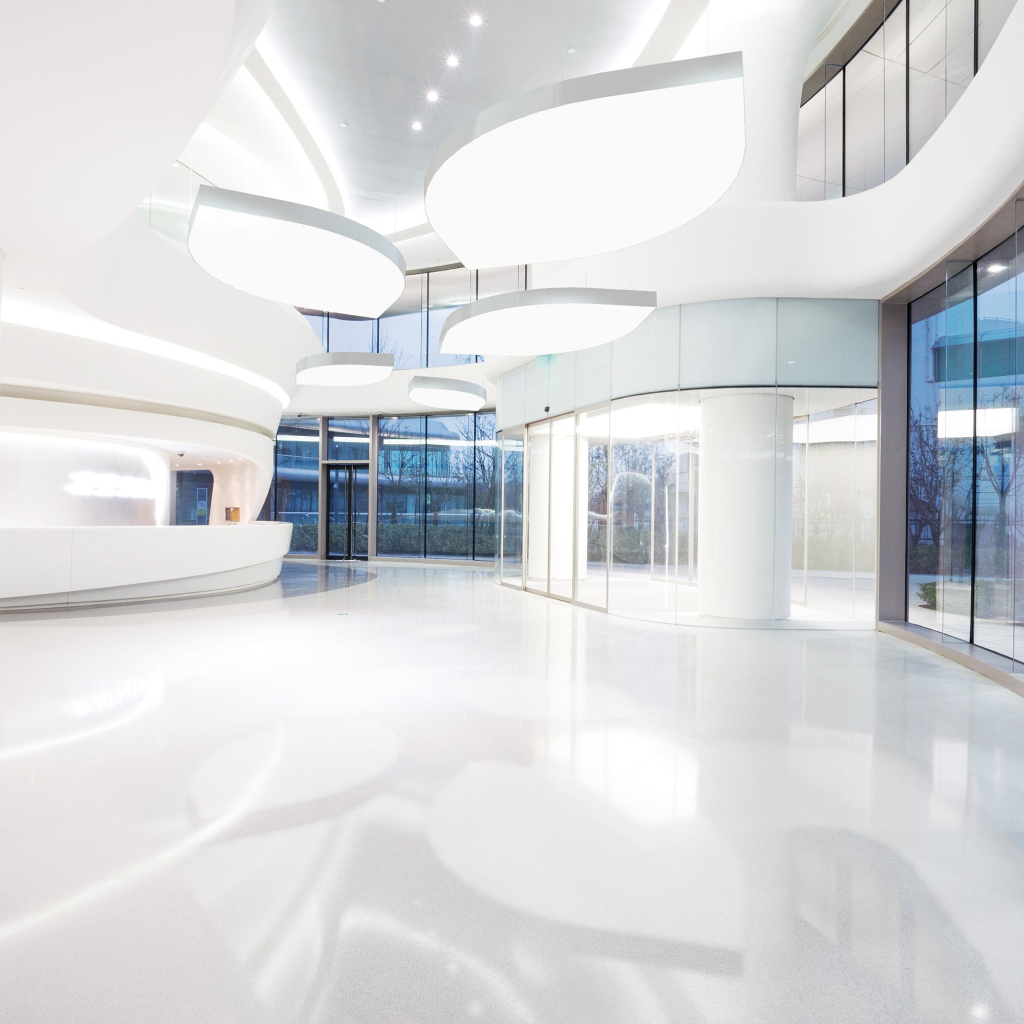 Integrated curved ceiling luminaires in minimalist white architectural lobby