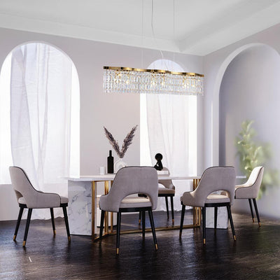 Modern dining room with gray chairs, a marble table, and a chandelier.
