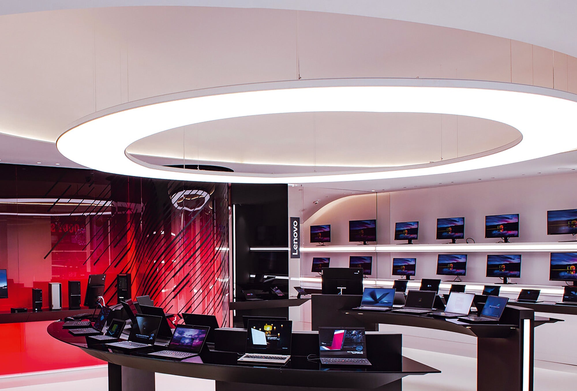Large circular architectural ceiling luminaire in modern retail electronics store interior