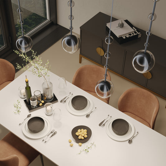 Dining table set with plates, glasses, and cutlery in a modern kitchen anf pendant lighting