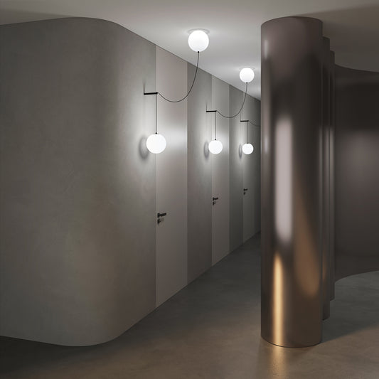 Modern hallway with pendant lights and a bronze cylindrical object.