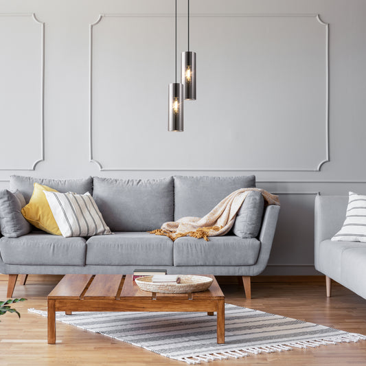Gray sofa with decorative pillows in a modern living room setting.