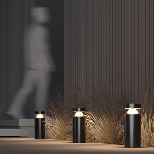 Modern outdoor lighting fixtures with grasses and a blurred figure in the background
