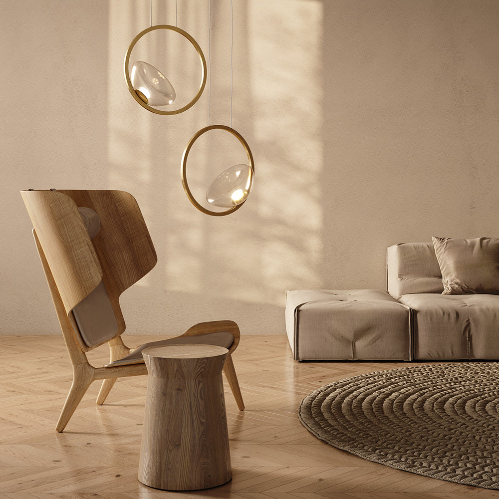 Modern living room with wooden chair, round stool, and sofa under hanging pendant lights.