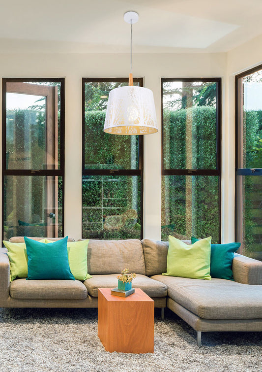 Modern living room with a beige sectional sofa, colorful pillows, and a wooden side table.