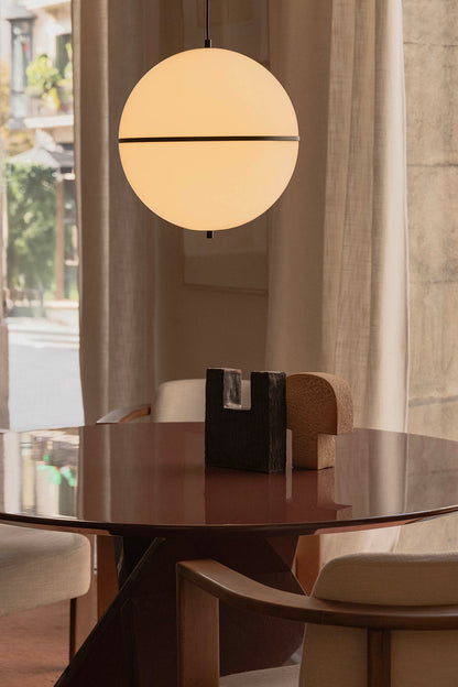Round dining table with a pendant light in a modern interior setting
