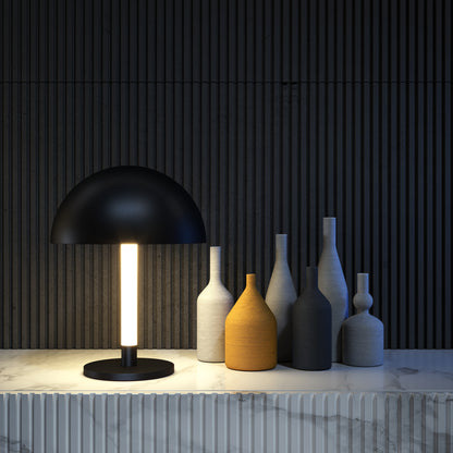 Black table lamp with a white light bulb on a marble surface against a dark wooden panel background.