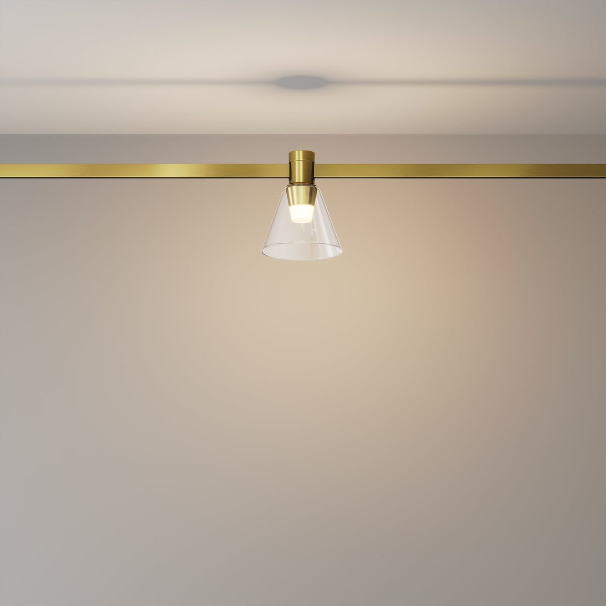 Modern ceiling light fixture with gold finish and clear glass shade on a neutral background