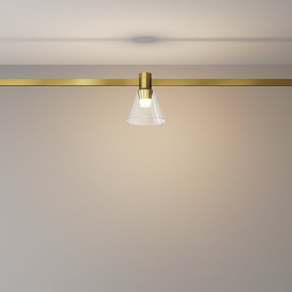Modern ceiling light fixture with gold finish and clear glass shade on a neutral background