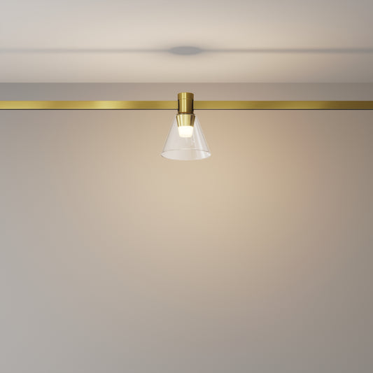 Modern ceiling light fixture with gold finish and clear glass shade on a neutral background