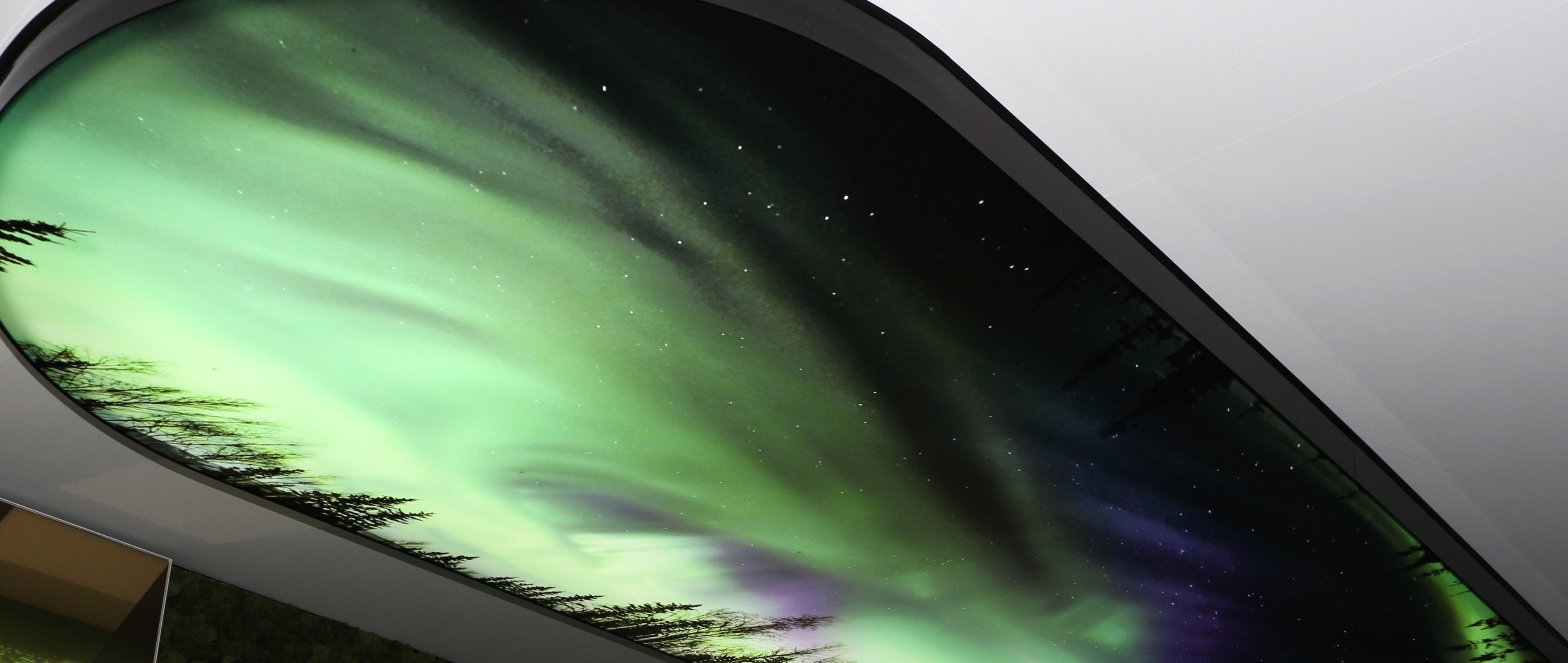 Backlit stretch fabric ceiling lightbox with printed aurora artwork in contemporary architectural space