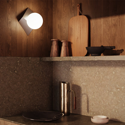 Modern kitchen with wooden shelves, a wall light, and various kitchen items.