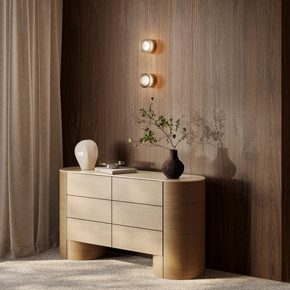 Modern wooden sideboard with decorative items against a wooden wall.